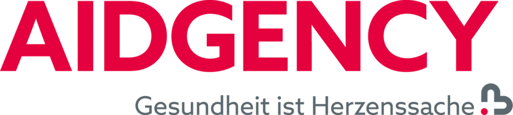 Das Bild zeigt das Wort AIDGENCY in fetten roten Buchstaben, darunter den deutschen Text „Gesundheit ist Herzenssache“ in kleineren grauen Buchstaben.